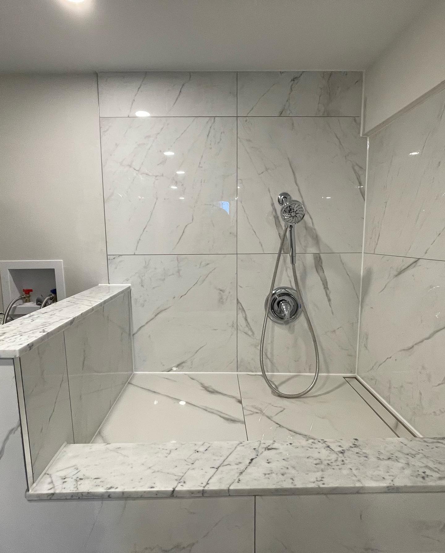 Tiled laundry sink with marble-look utility backsplash