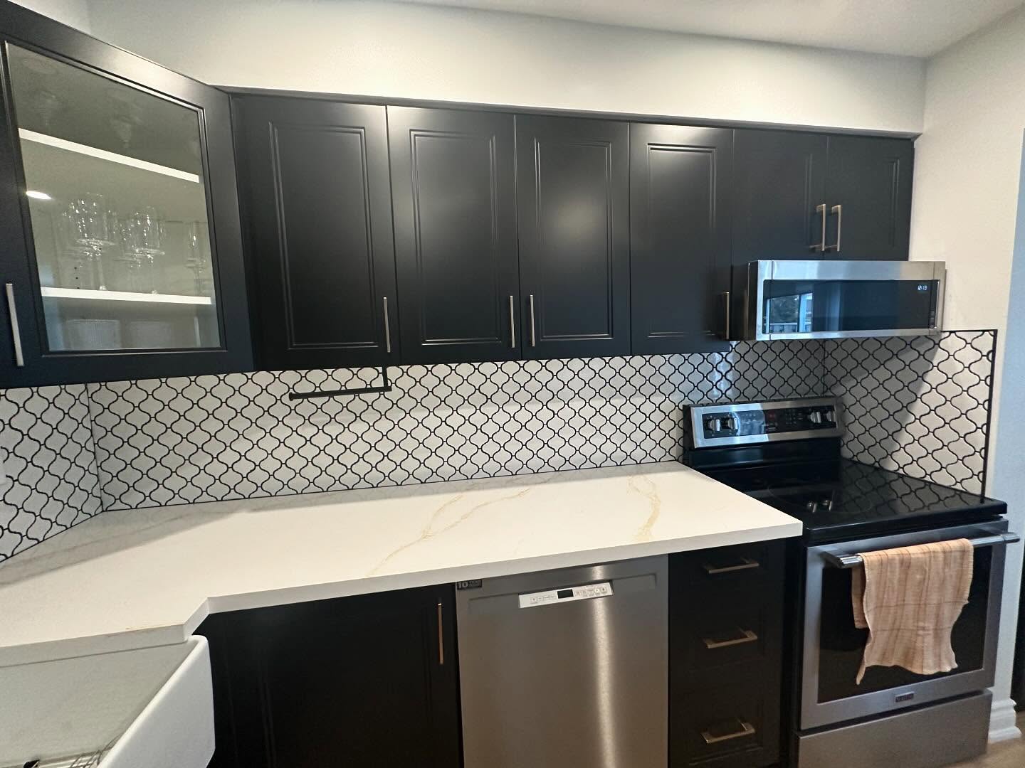 Kitchen renovation with black cabinets and patterned backsplash