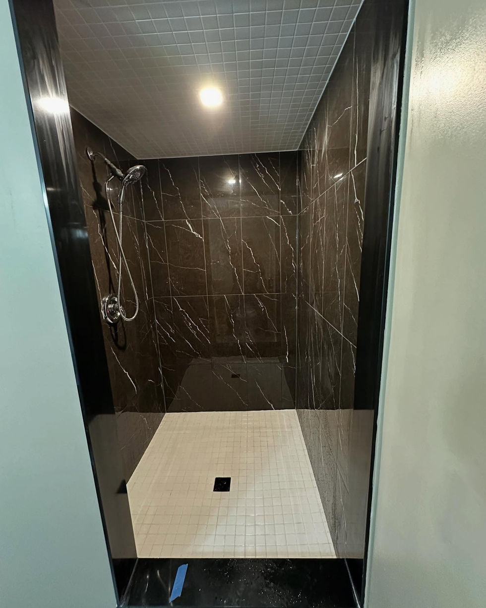 Dark stone bathroom tile installation